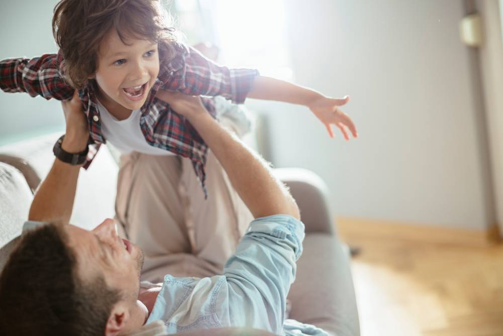 Dad raising little boy overhead