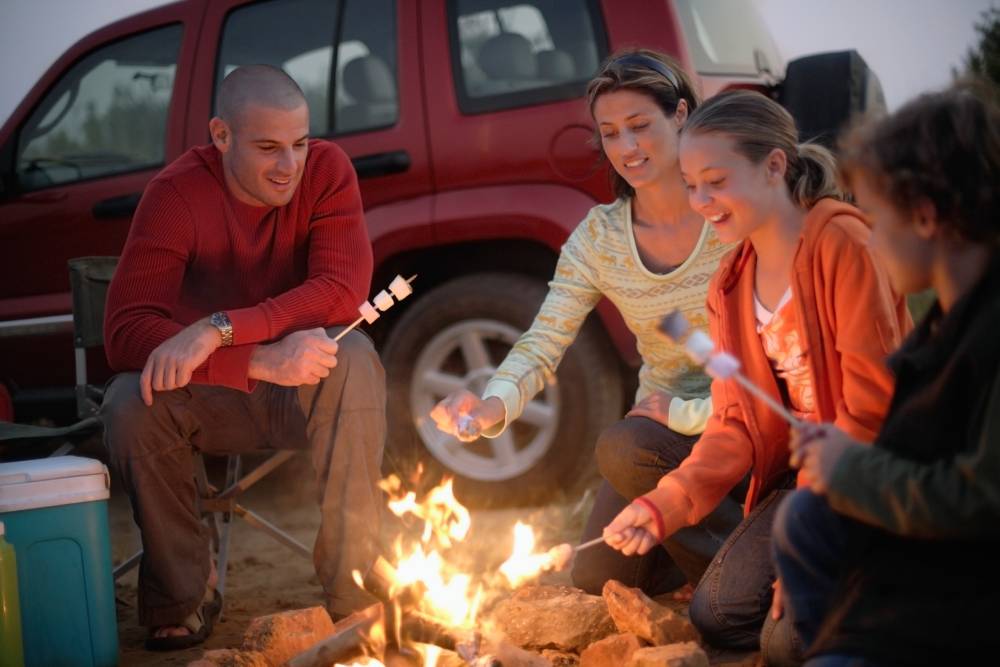 Familt roasting marshmallows together.