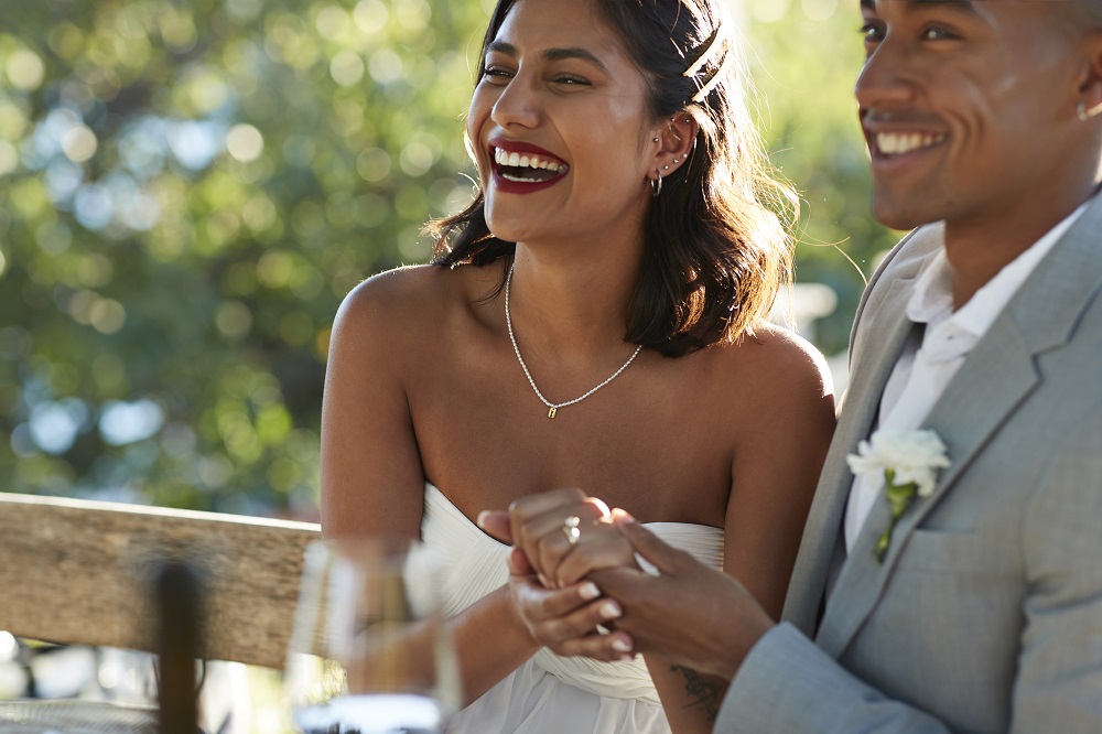 Newly married couple laughing at their wedding.