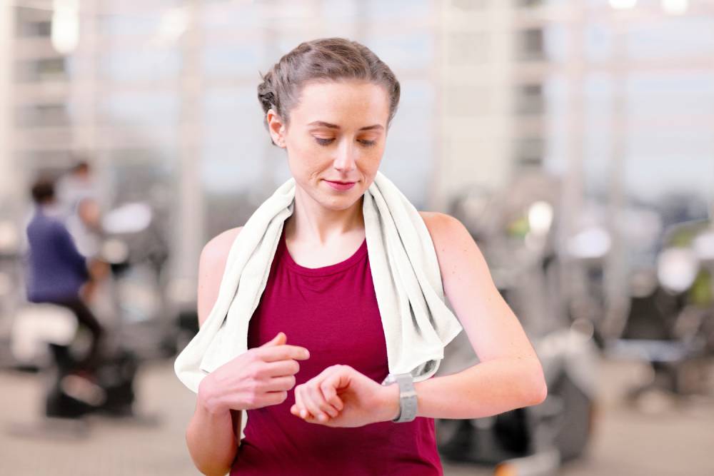 Woman looking at her smartwatch in the gym while earning Well OnTarget rewards.