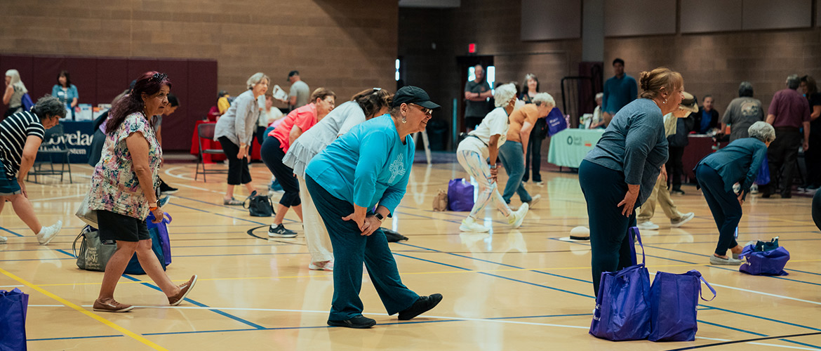 A group of older people participate in an exercise class
