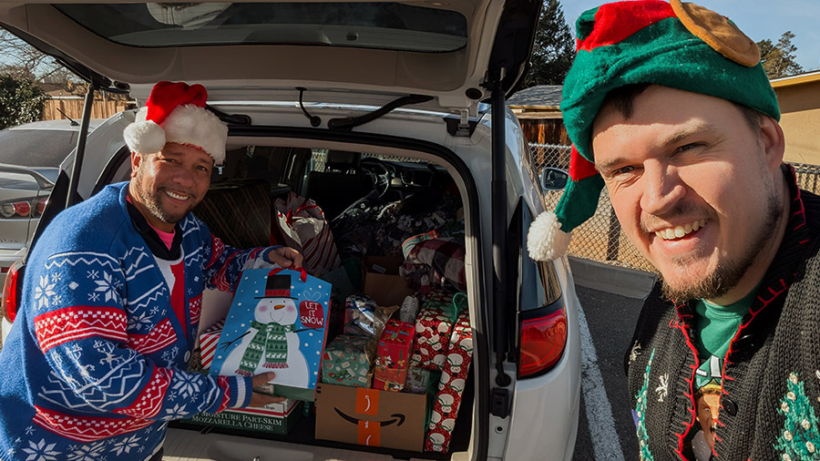 Two men  load holiday gifts into a vehicle