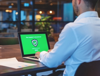 Hombre mirando una computadora portátil con una pantalla de seguridad.